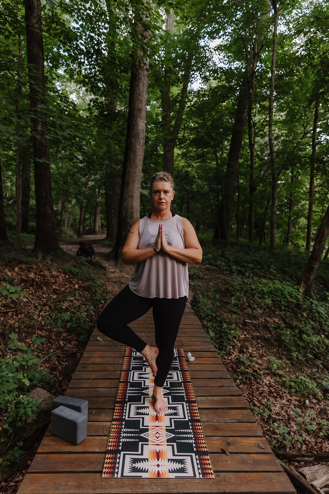 Business Brand photos session of yoga instructor doing a tree pose in a wooded area within an Eastern Iowa park near Cedar Rapids, Iowa.
