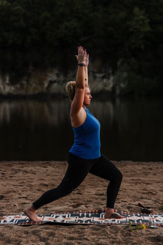 Cedar Rapids branding photographer capturing small business owner practicing yoga on sandbar at Palisades-Kepler State Park.